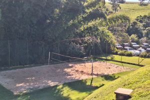 quadra de areia, volei e estacionamento aos fundos